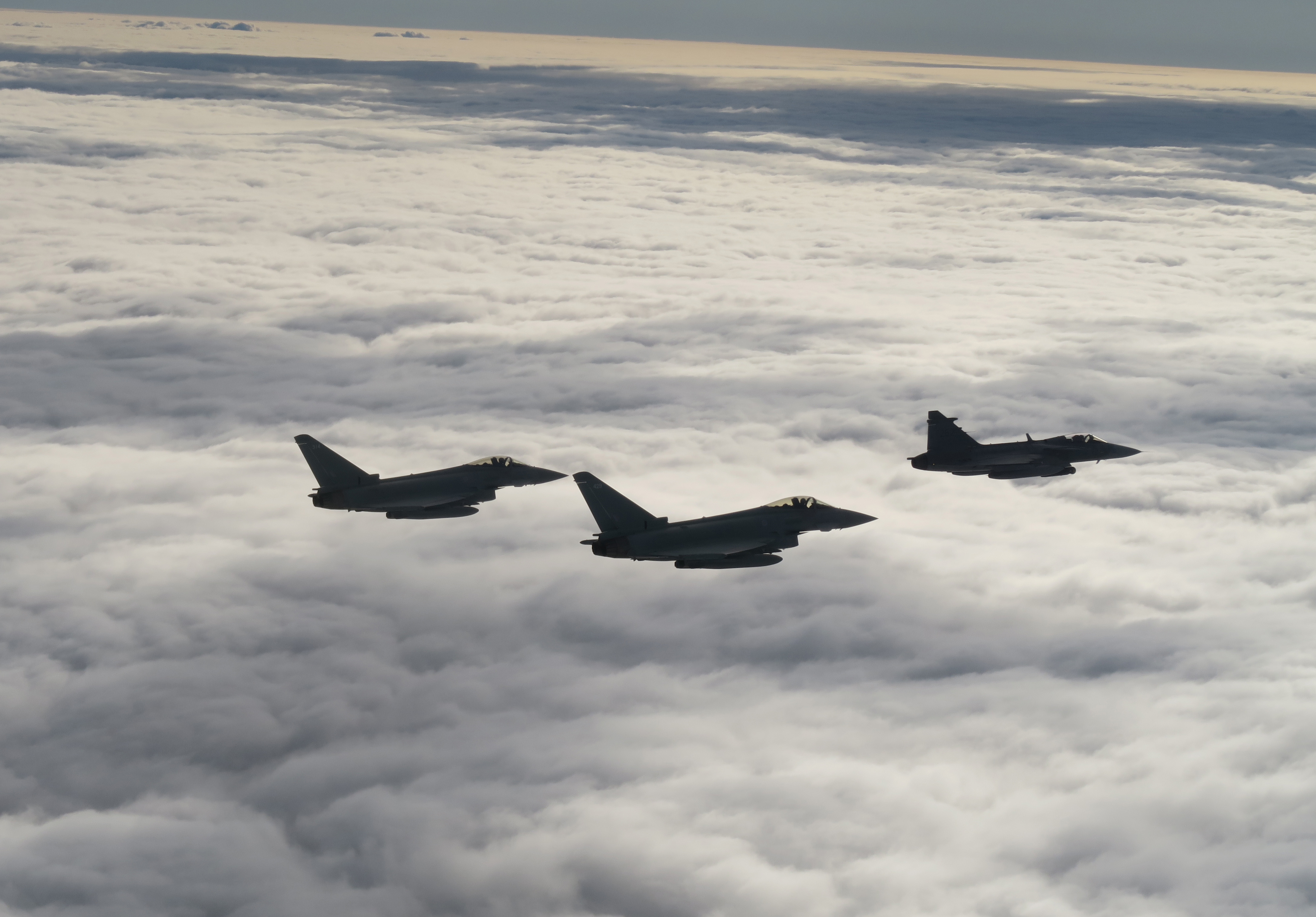 Image shows three Typhoons flying through the clouds in formation.